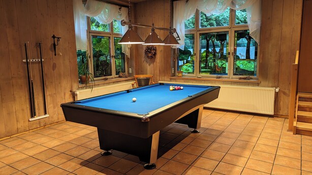 A pool table in a room with wooden walls and large windows. - Naturhotel Forsthaus (Annaberg-Buchholz)