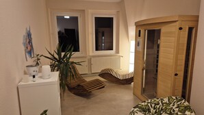 Un pasillo estrecho con una puerta de madera, un banco, un radiador y una ventana.