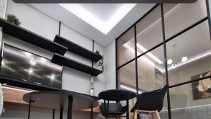 A modern kitchen with a dining area, featuring a large window, a built-in oven, and a countertop.