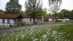 Eine Reihe traditioneller Fachwerkhäuser mit einer grünen Wiese im Vordergrund.