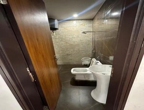 A bathroom with a toilet, bidet, and sink.
