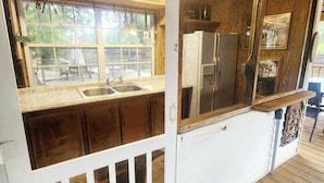 Eine Küche mit Fenster, Spüle und Kühlschrank.