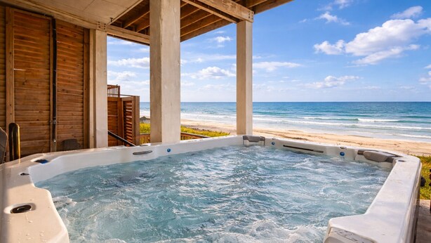 Un bain à remous avec vue sur la plage et l’océan.