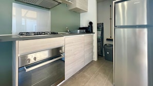 Eine moderne Küche mit Edelstahl-Kühlschrank, Backofen und Gasherd.