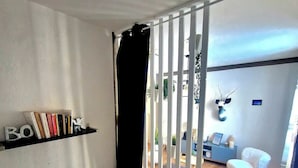 Une chambre à coucher avec un lit, une bibliothèque et une vue sur l’extérieur.