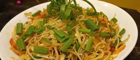 A plate of stir-fried noodles with vegetables.