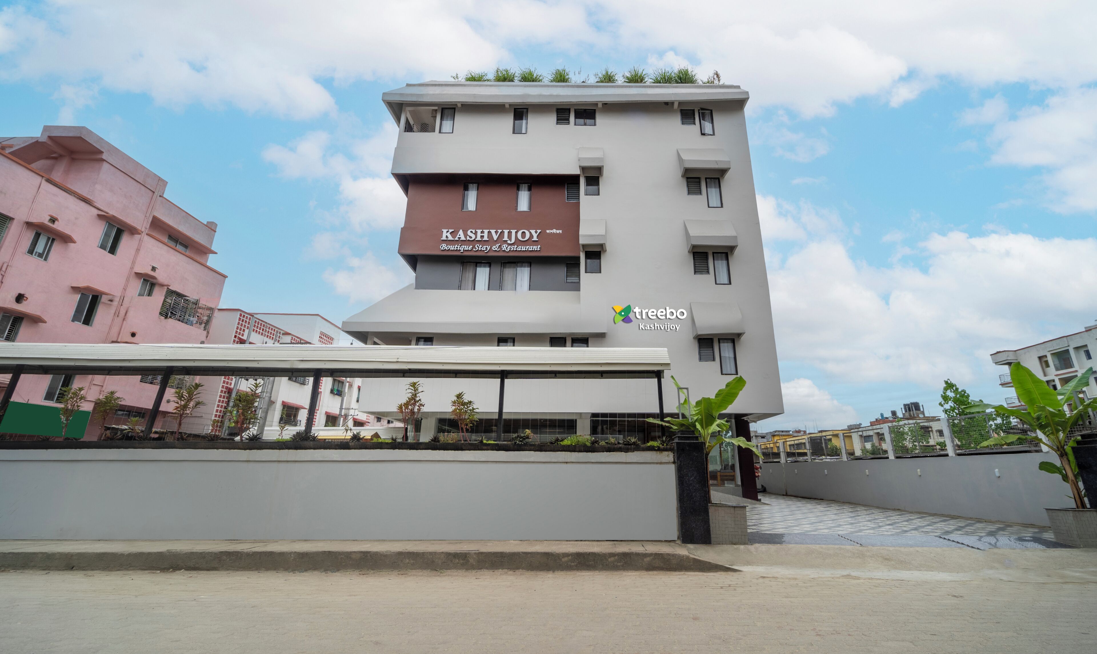 A multi-story building with a sign for 'Kashvijoy Boutique Stay & Restaurant'.