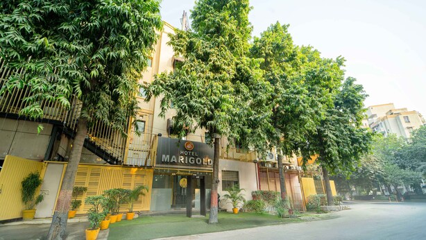 Un hotel llamado Marigold con una fachada moderna, amplias ventanas y un césped bien cuidado.
