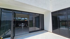 A modern building with large glass doors leading to a balcony area. - Muguet by Ibiscot Development (Entebbe)