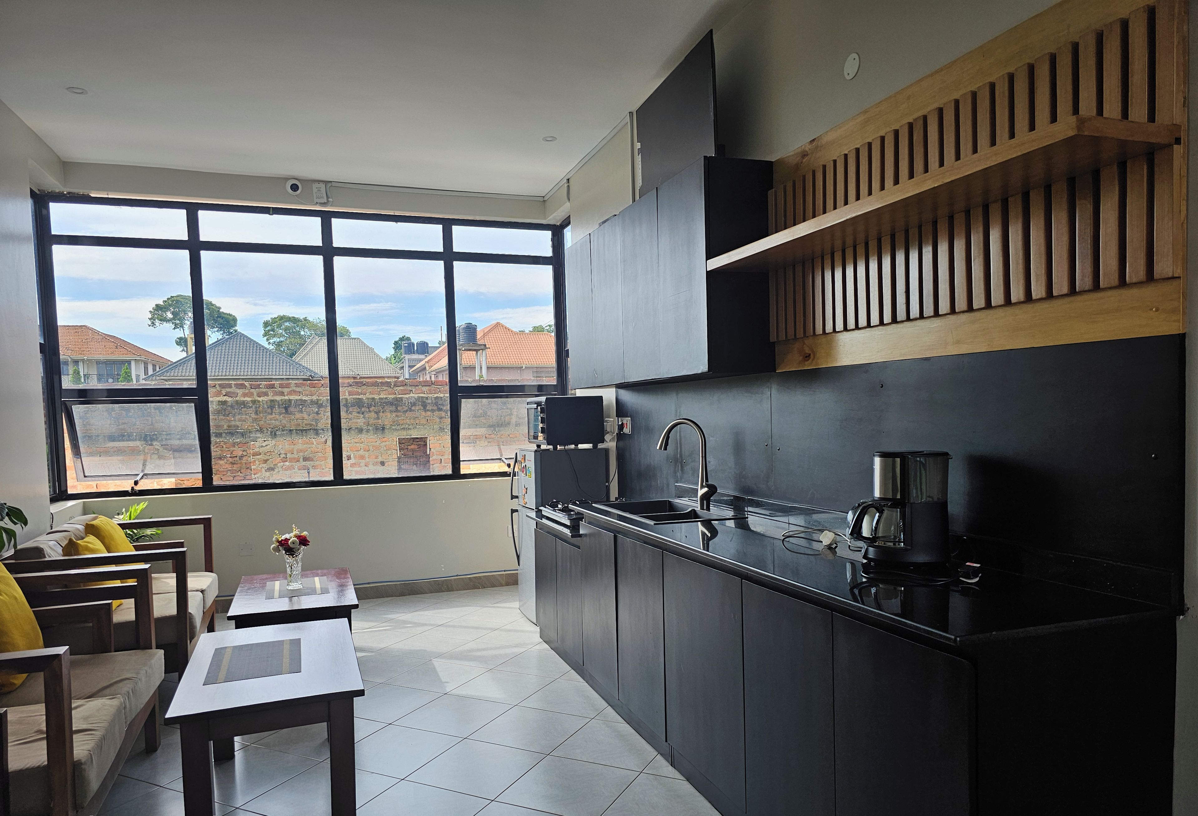A modern kitchen with a large window, a sink, and a coffee maker.
