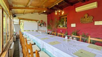 A long dining table with chairs, a whiteboard, and a red wall with decorations.