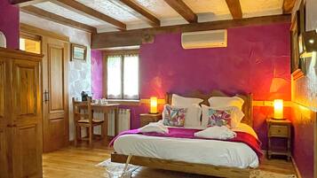 Een slaapkamer met een bed, nachtkastjes, een bureau en een stoel.