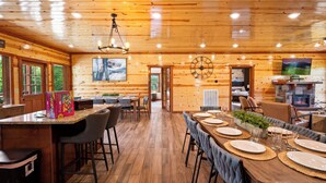 Un interno in legno con zona pranzo, bar e camino.