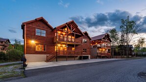 Un'ampia baita di legno con diversi balconi e un portico coperto.