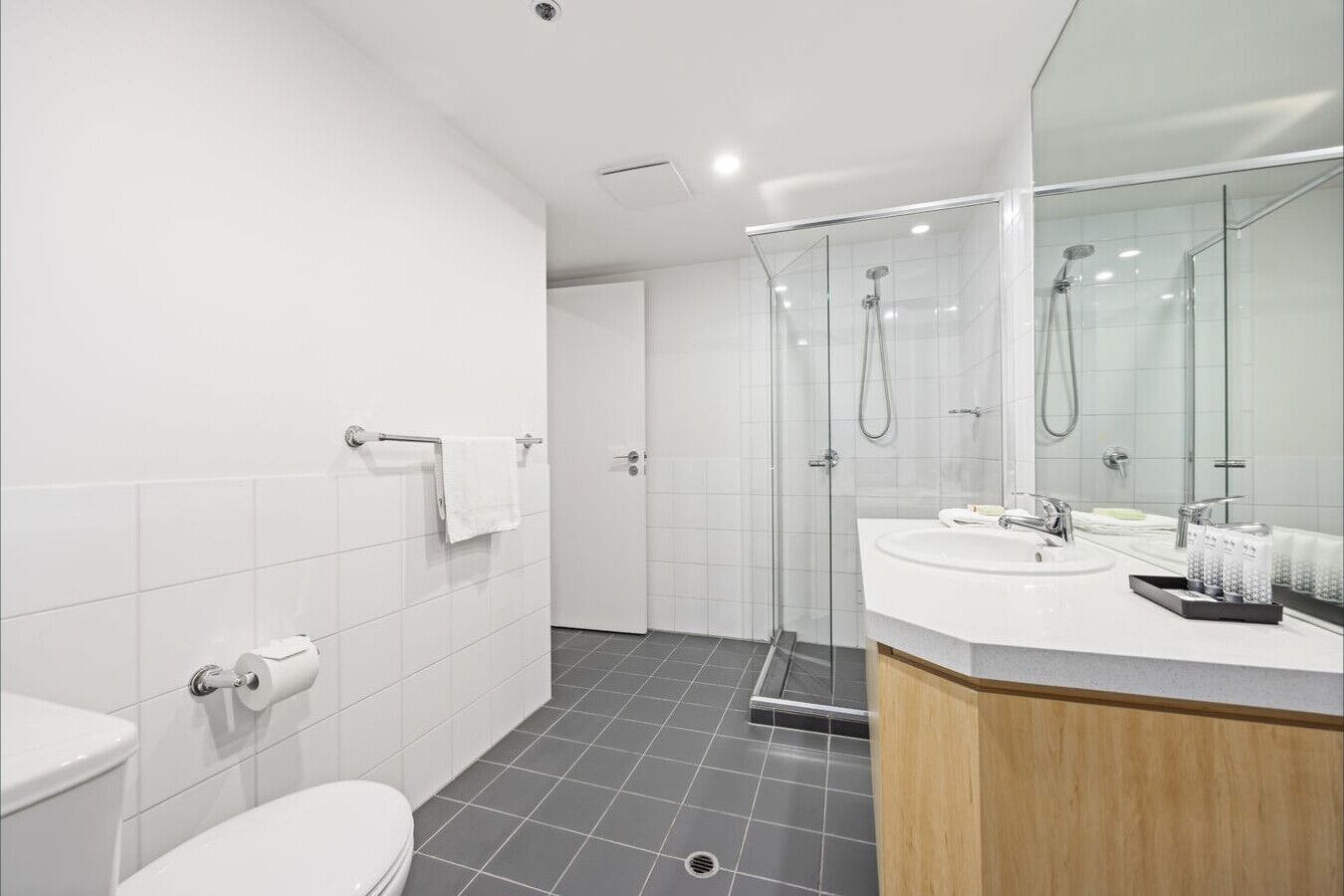 A modern bathroom with a toilet, sink, and shower area.