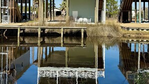 A waterfront property with a main house and two smaller structures, connected by a covered walkway over water. - The Bay Stay has boat pier ~ 4 mi. to Beach. Cart into town- Close to Boat ramp  (Bay St. Louis)