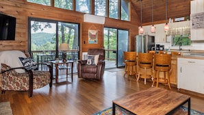 A spacious cabin with a wooden interior, large windows, a dining area, and a kitchen. - Serene Cabin - Incredible VIEWS, 3 Bedrooms, 3 Bathrooms, Family & Pet-Friendly! (Deep Gap)