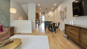 A modern living room with a sofa, a coffee table, and a TV mounted on the wall.