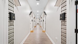 Un pasillo largo y estrecho con taquillas a ambos lados y suelo de madera.