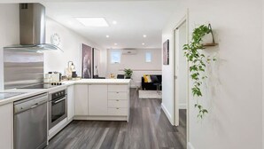 Una cocina moderna con armarios blancos, electrodomésticos de acero inoxidable y una isla central.