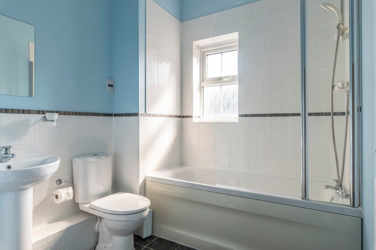 A bathroom with a toilet, sink, and bathtub.
