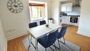 Une cuisine moderne avec des meubles blancs, un lave-vaisselle et une cuisinière.