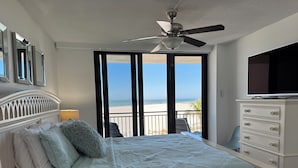 A bedroom with a bed, a ceiling fan, a dresser, and a TV. - Marco Island Vacation Rental, Beachfront Condo with Unobstructed Gulf Views,Pool (Marco Island)