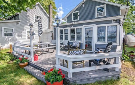A covered deck with outdoor seating and a view of the water.