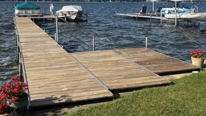 Un muelle de madera que se adentra en un lago, con barcos amarrados al final.