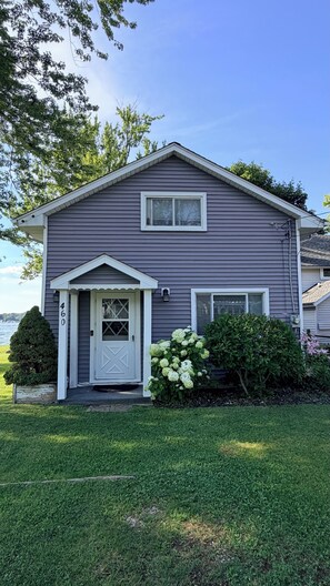 A two-story house with a front porch, a mailbox, and a number '460' on the door.