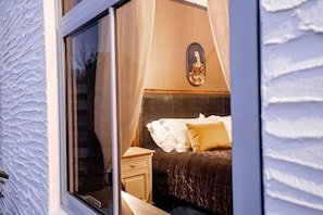 Un dormitorio con una cama, mesita de noche y un adorno en la pared.