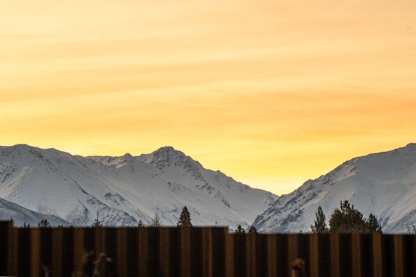 A mountain landscape with snow-covered peaks and a clear sky.