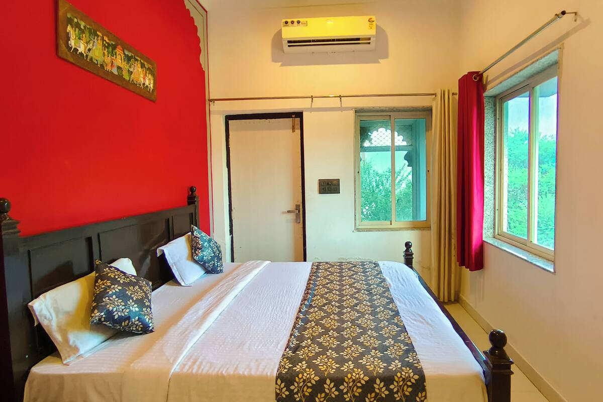 Una habitación con cama, puerta, ventana y aire acondicionado.
