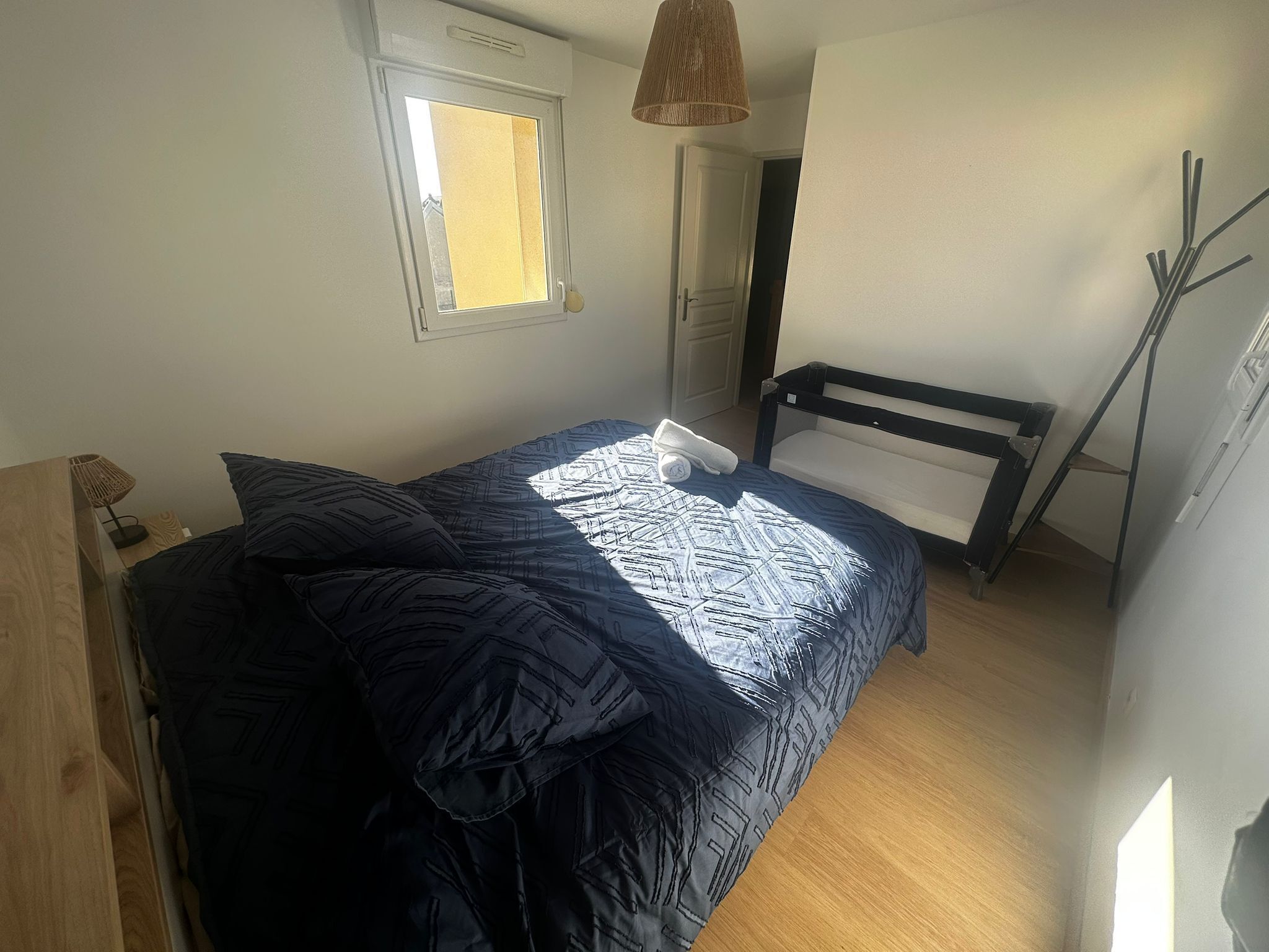 Une chambre à coucher avec un lit, une fenêtre, une porte et une lampe.