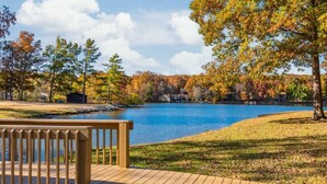 Une vue sur le lac, avec une terrasse en bois et le feuillage automnal.