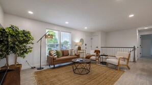 A modern living room with a sofa, armchairs, a coffee table, and a large plant. - 5BD I Game Room I Backyard & BBQ I 20 Mins to DEN (Thornton)