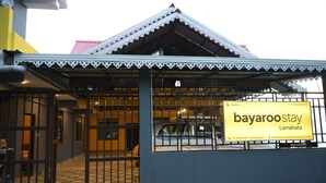 A hotel with a traditional architectural style, featuring a tiled roof and a gated entrance. - Bayaroo Stay Lamahatta (Darjeeling)