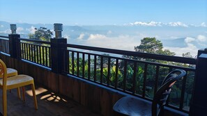 Un balcon avec vue sur les montagnes et les nuages.