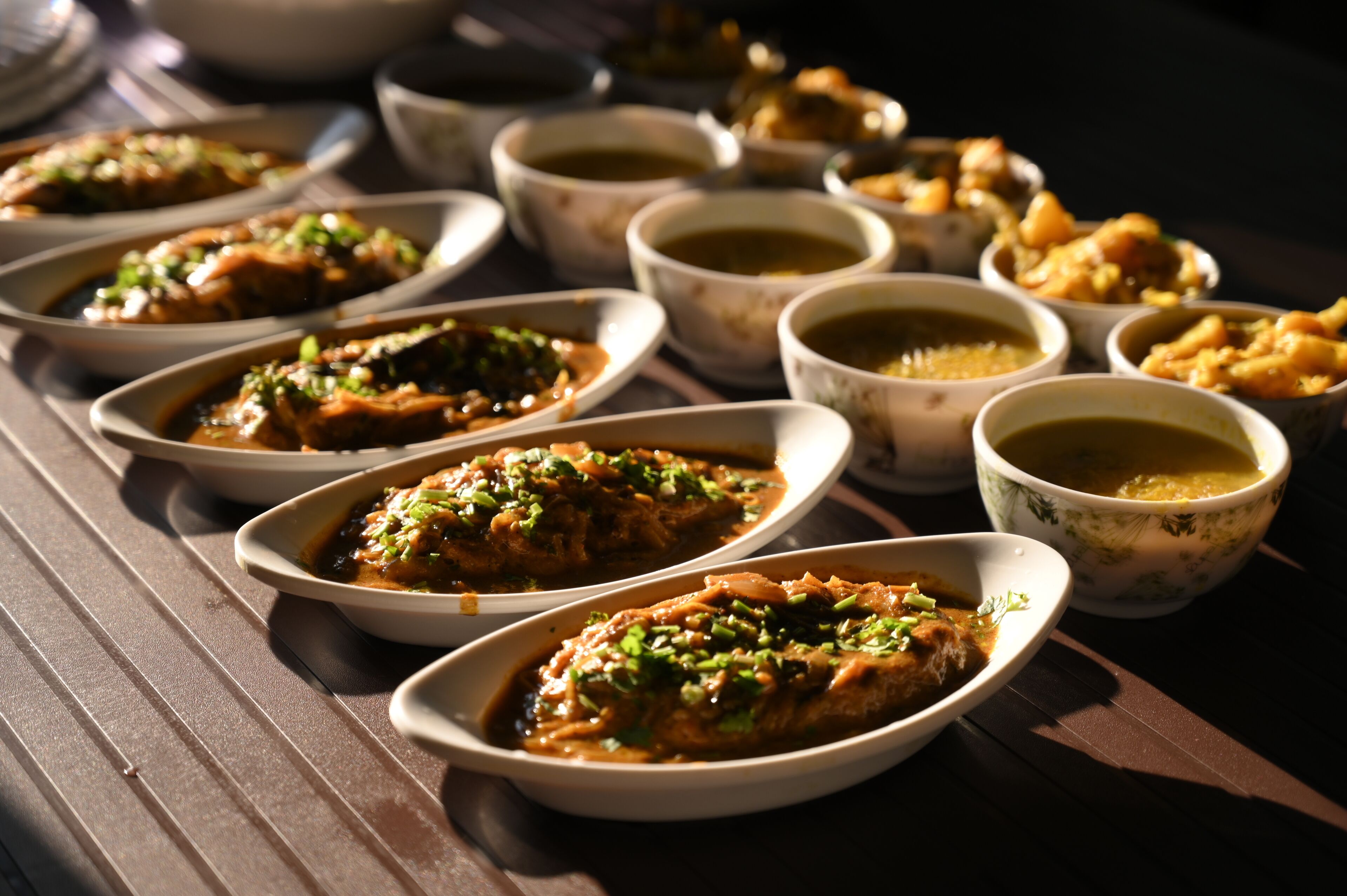 Una mesa con varios platos, incluyendo sopas en cuencos y comida decorada con hierbas.