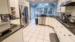 A modern kitchen with white cabinets, stainless steel appliances, and a black countertop. - Grand Lakeview Retreat Near Town • Game Rm • 4BR (Princeton)
