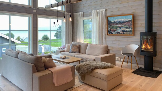 A cozy living room with a sofa set, a coffee table, a fluffy throw, and a fireplace. - 4 bedroom nice home in Hildre (Hildre)