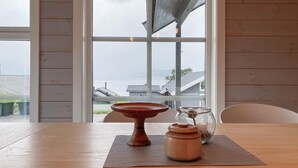 A wooden table with a woven placemat, a wooden bowl, a glass jar, and a candle. - 4 bedroom nice home in Hildre (Hildre)