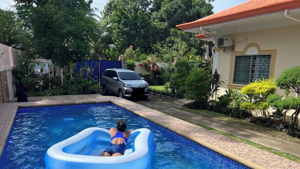 Una piscina amb una persona en un flotsam blau inflable.
