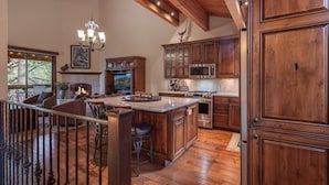 Una cocina amplia con armarios de madera, una isla grande y una chimenea.