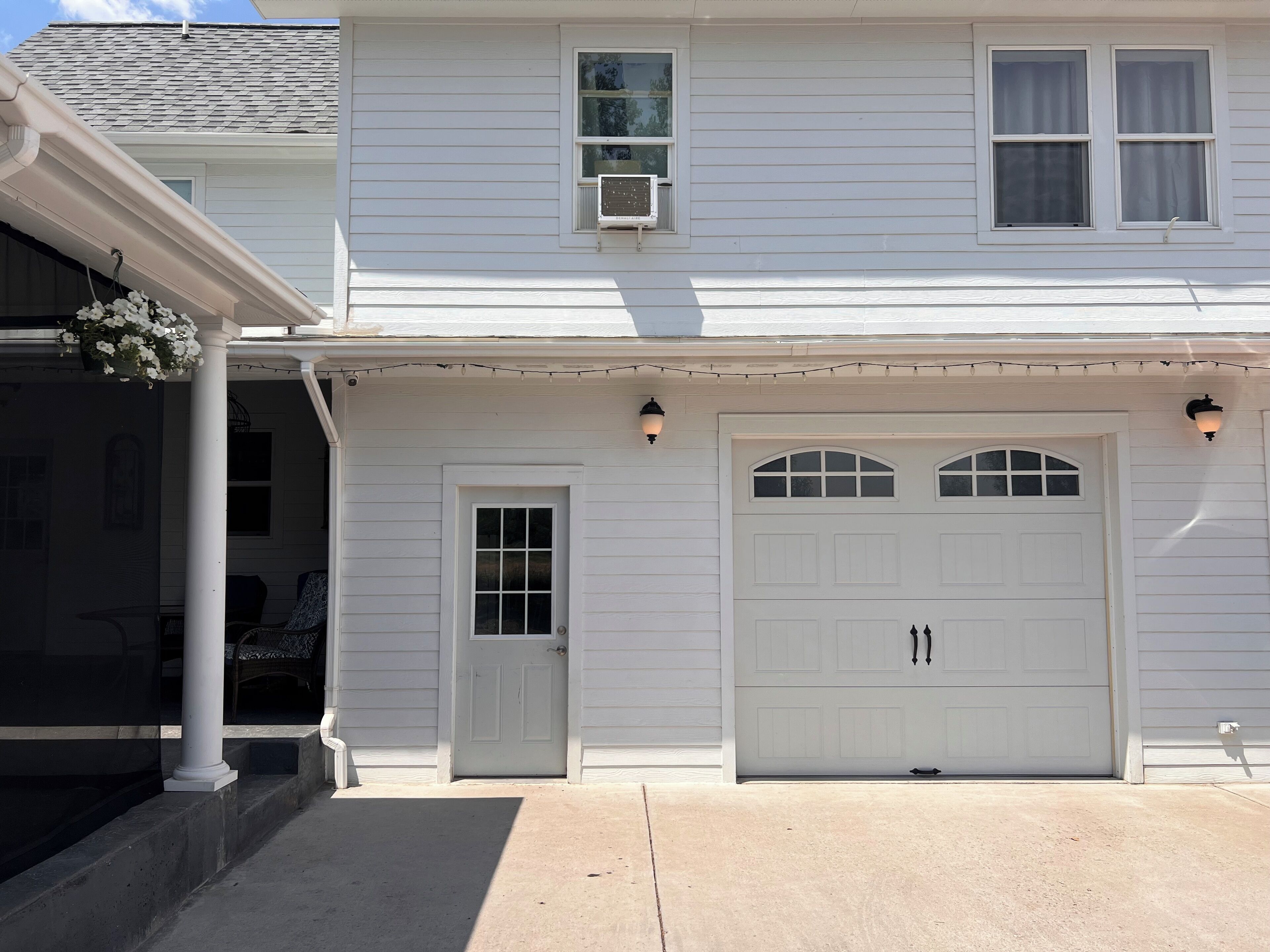 A two-story house with a front porch, a garage, and a covered entryway.