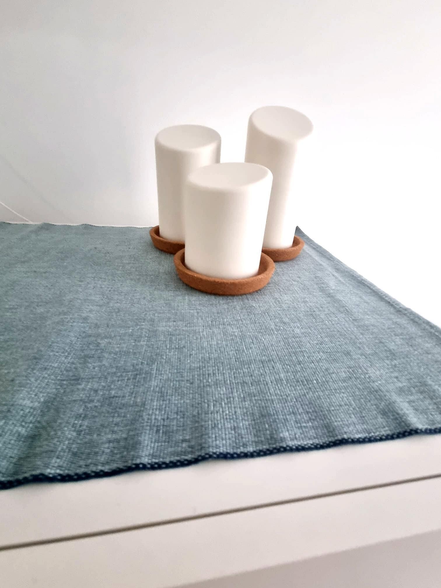 Three white cylindrical objects on a textured blue cloth.