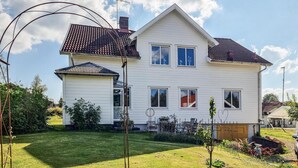 A two-story house with a sloped roof, multiple windows, and a well-maintained lawn.