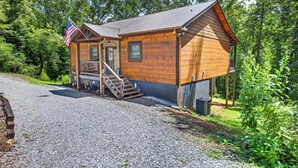 A wooden cabin with a porch, a staircase, and a flag. - Squirrels Hideaway | Fire Pit | MTN Views (Copperhill)