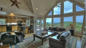 A spacious living room with a large window, a cozy fireplace, and a comfortable seating area. - Champagne Chalet | MTN Views | Hot Tub | Secluded (Morganton)