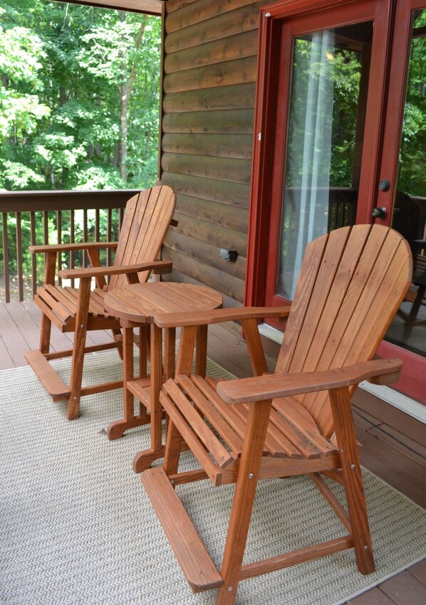 A wooden deck with Adirondack chairs and a small table. - Sweet Retreat | Mtn Views | Hot Tub | Pet Friendly (Blue Ridge)